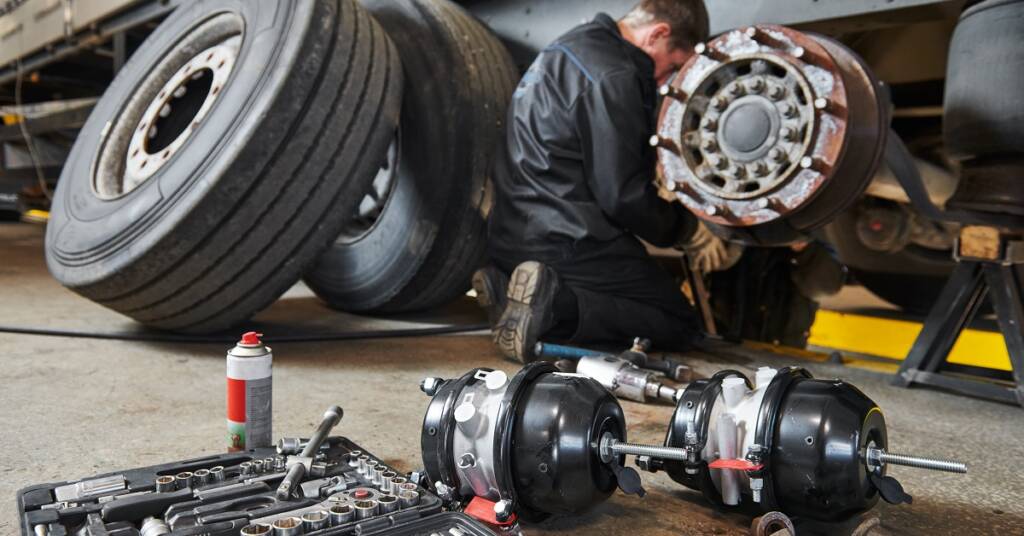 Truck repair service. Mechanic takes off tyre for brake replacement
