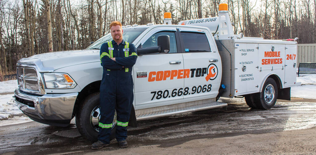 Automotive technician in full uniform standing in front